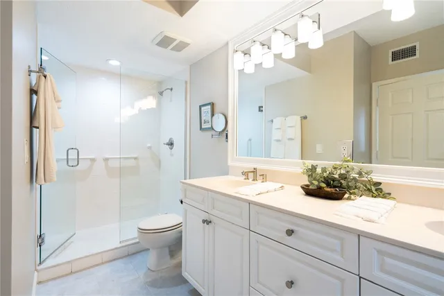 a bathroom with a granite countertop sink a toilet and shower