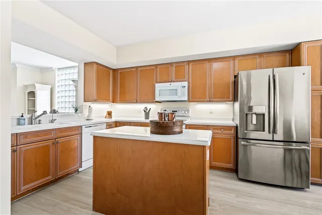 a kitchen with granite countertop a refrigerator stove top oven and sink