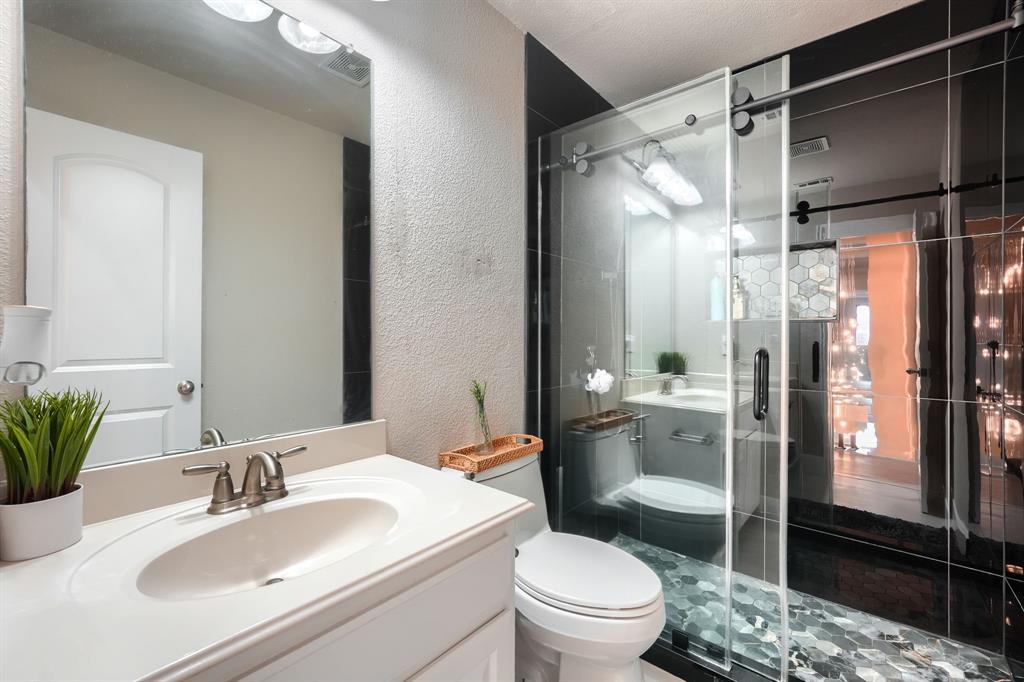 2246 Longview Road Irving, TX 75063 - Photo 34 of 40 Bathroom featuring a white vanity with integrated sink, brushed nickel faucet, and a large wall-mounted mirror