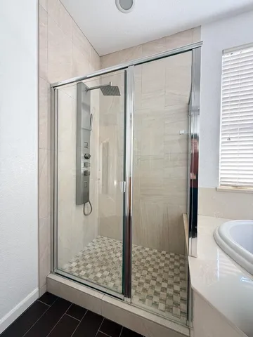 a bathroom with a glass shower door