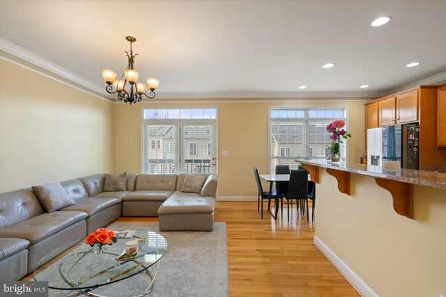 a living room with furniture dining table a chandelier and a dining table