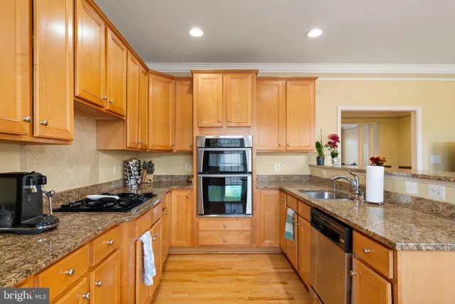 a kitchen with stainless steel appliances granite countertop a sink stove and cabinets