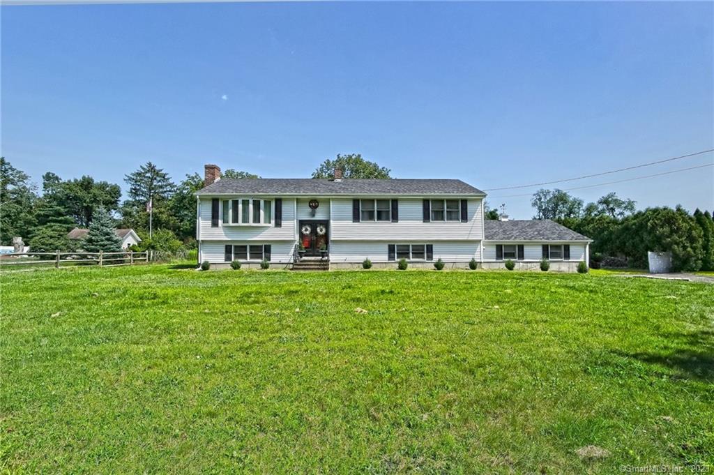 a front view of a house with a garden and trees