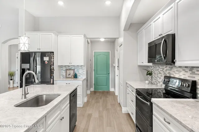 a kitchen with a sink appliances and cabinets