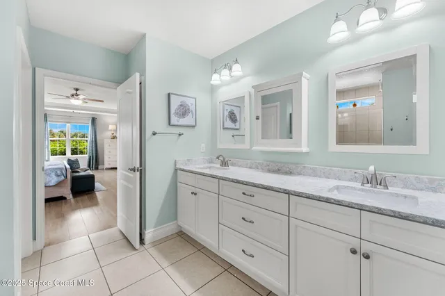 a bathroom with a granite countertop bathtub shower sink vanity mirror and toilet