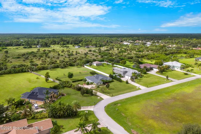 an aerial view of residential houses with outdoor space and river