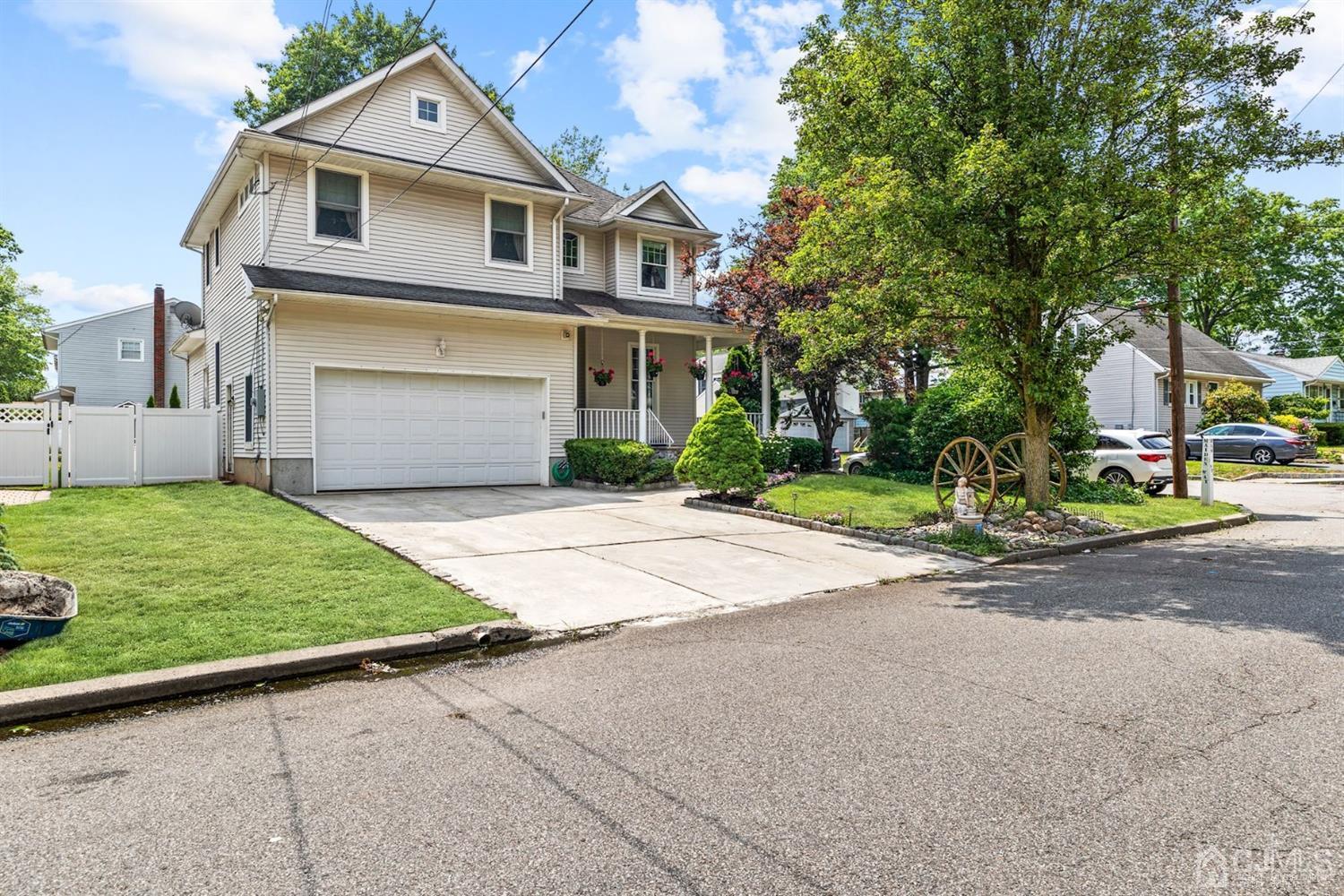 89 Elm Street Colonia, NJ 07067 - Photo 2 of 29 a front view of a house with a yard and garage