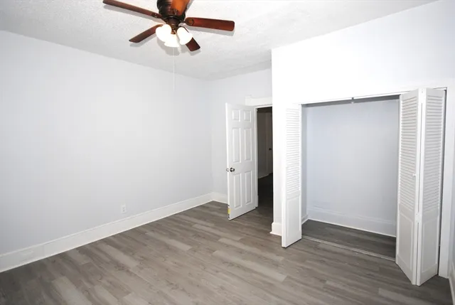 an empty room with wooden floor a ceiling fan