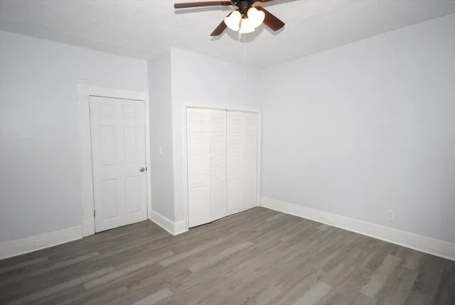 a view of an empty room with wooden floor
