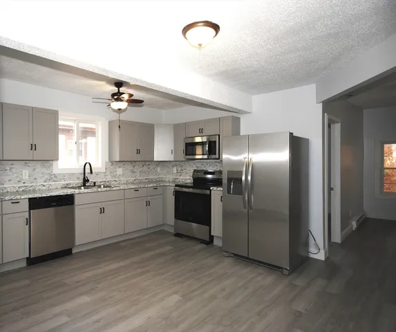 a modern kitchen with stainless steel appliances granite countertop a stove and a sink