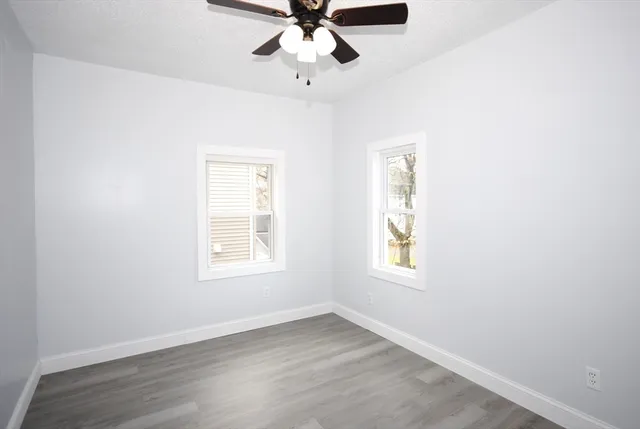 an empty room with a window and a fan