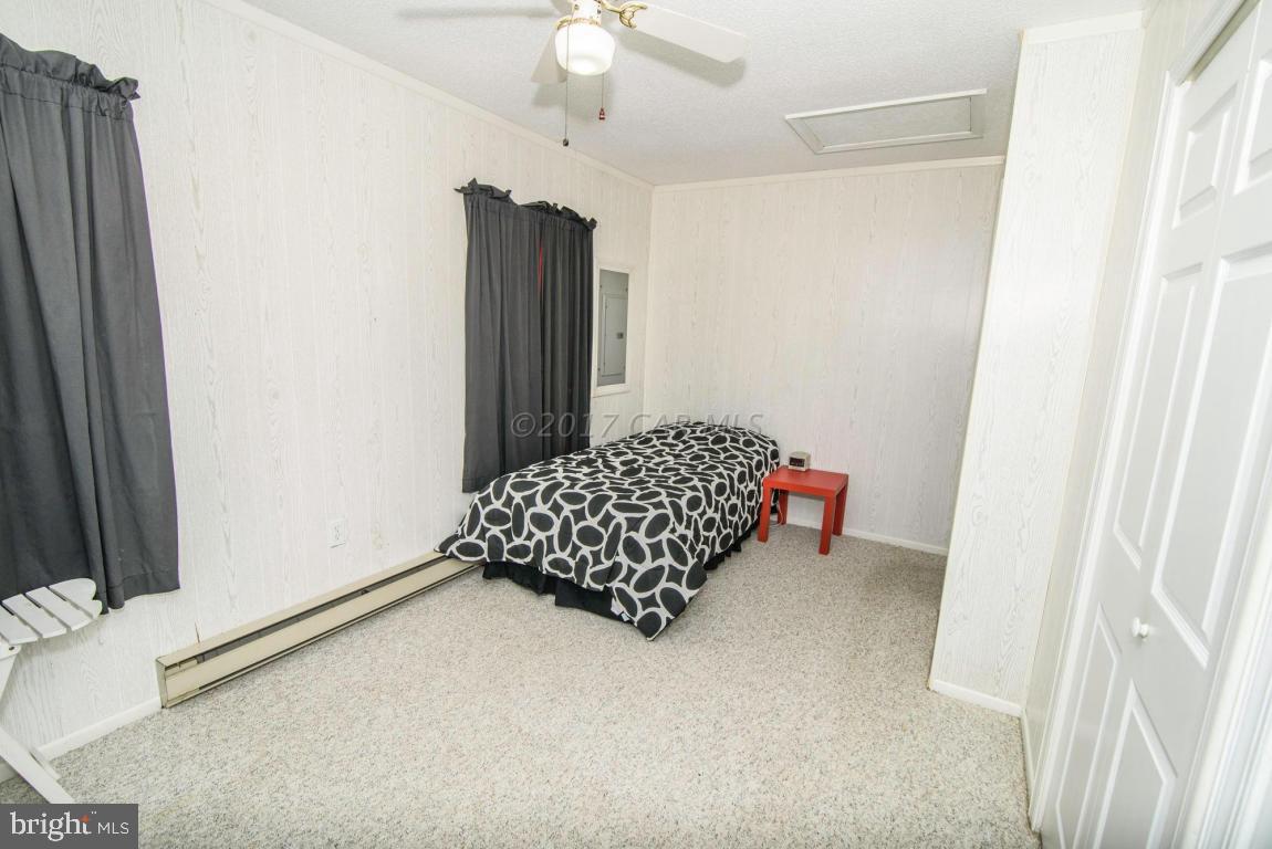 125 Pinehurst Road Ocean Pines, MD 21811 - Photo 17 of 49 a room with bed and a chandelier