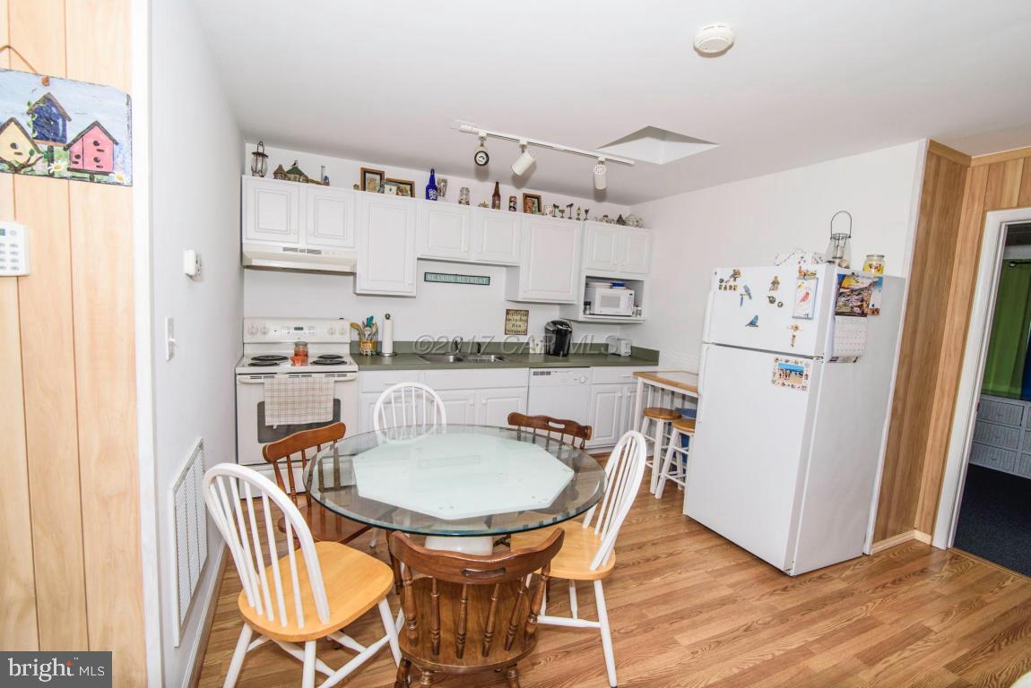 125 Pinehurst Road Ocean Pines, MD 21811 - Photo 3 of 49 a kitchen with stainless steel appliances granite countertop a dining table chairs refrigerator and sink
