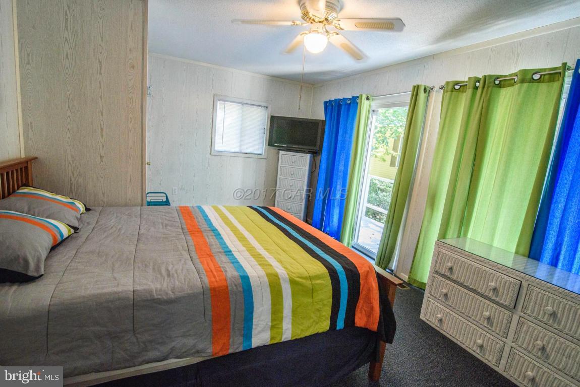 125 Pinehurst Road Ocean Pines, MD 21811 - Photo 30 of 49 a bedroom with a bed and a chandelier