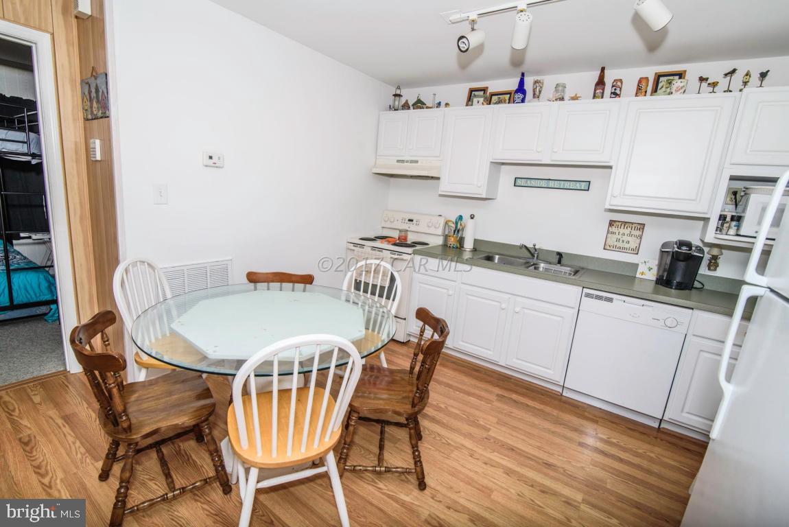 125 Pinehurst Road Ocean Pines, MD 21811 - Photo 9 of 49 a kitchen with a dining table chairs and white cabinets