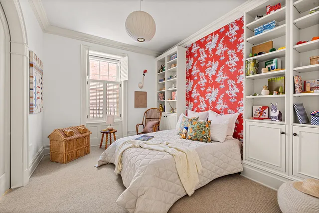 a bedroom with bed and a book shelf