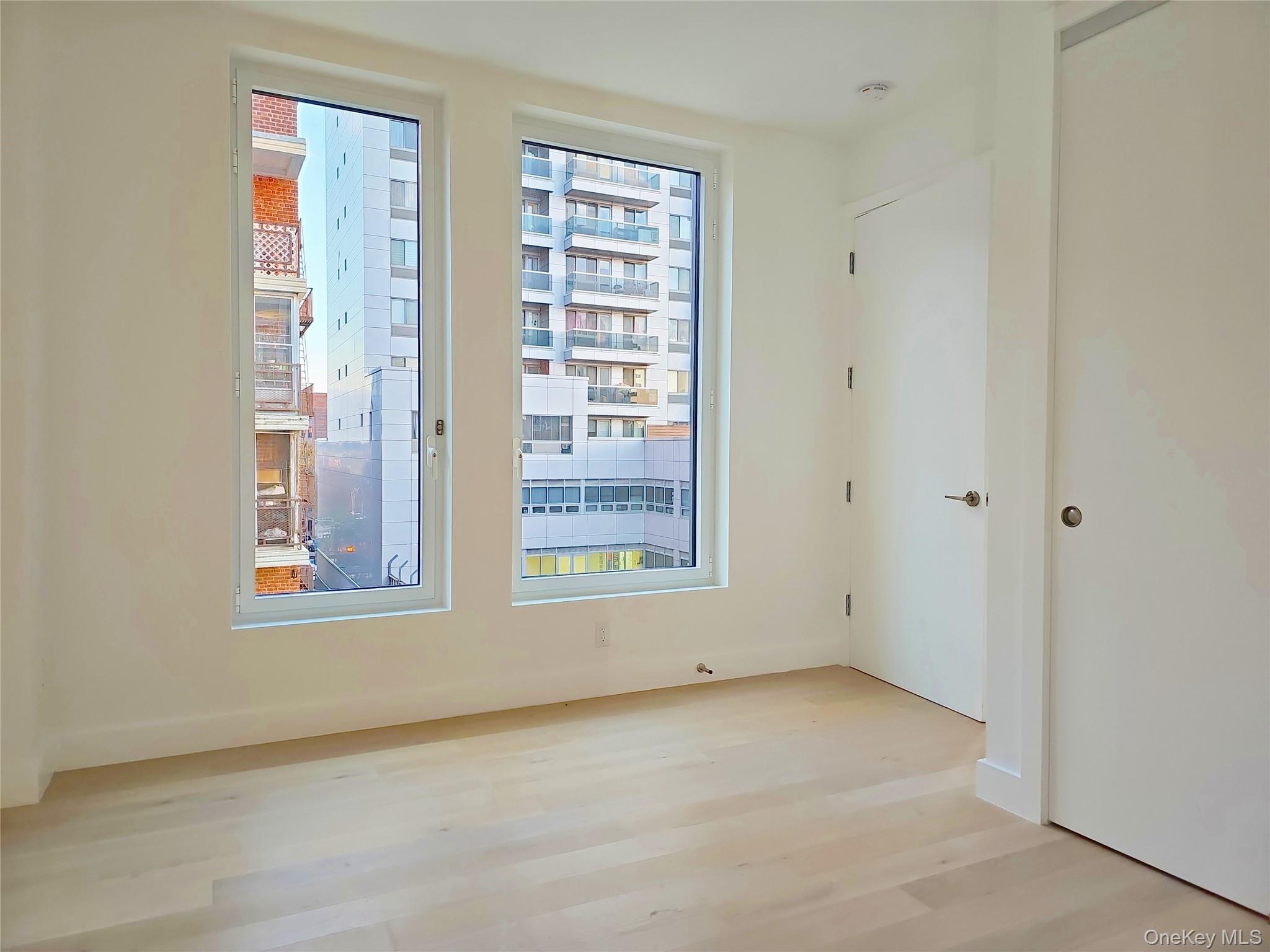 136-18 Maple Avenue, Unit 5B Queens, NY 11355 - Photo 18 of 31 an empty room with windows