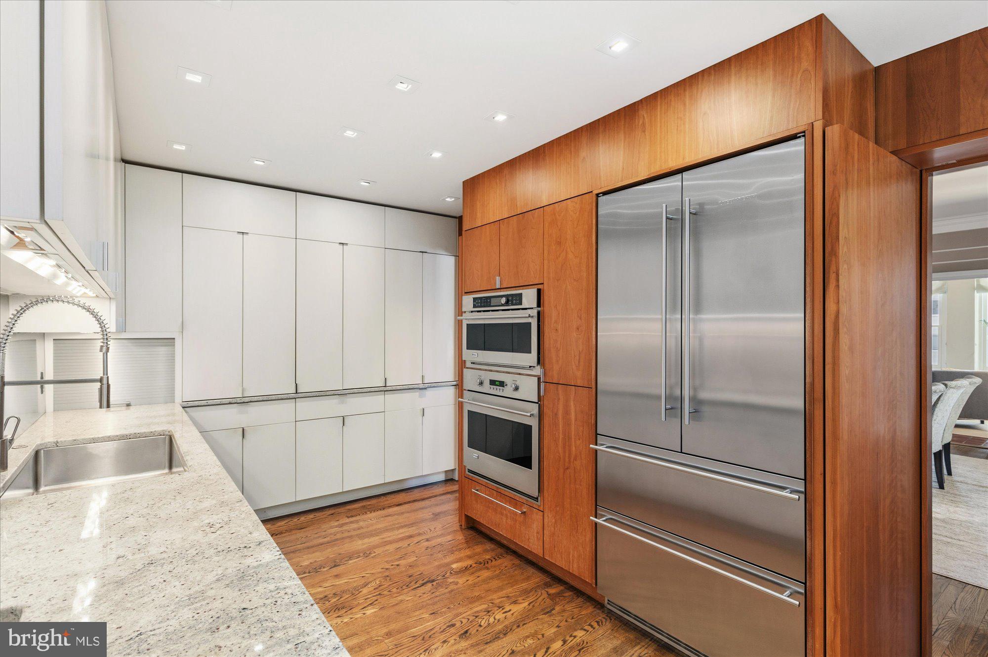 2101 Connecticut Avenue Northwest, Unit 53 Washington, DC 20009 - Photo 16 of 45 a kitchen with stainless steel appliances kitchen island granite countertop a refrigerator and a stove top oven