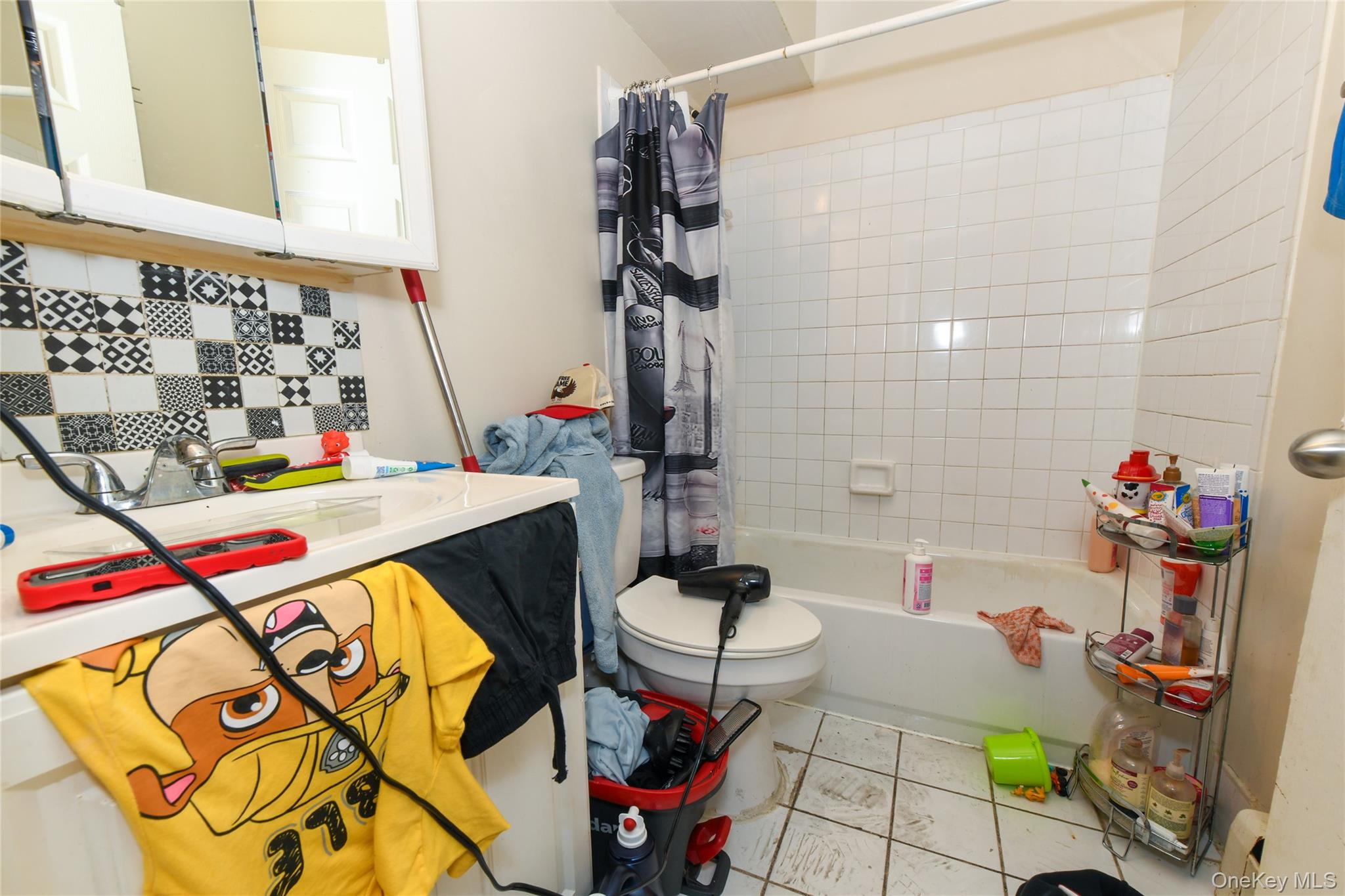 107-41 Sutphin Boulevard Queens, NY 11435 - Photo 14 of 19 Full bathroom with shower / bathtub combination with curtain, tile patterned flooring, and a baseboard heating unit