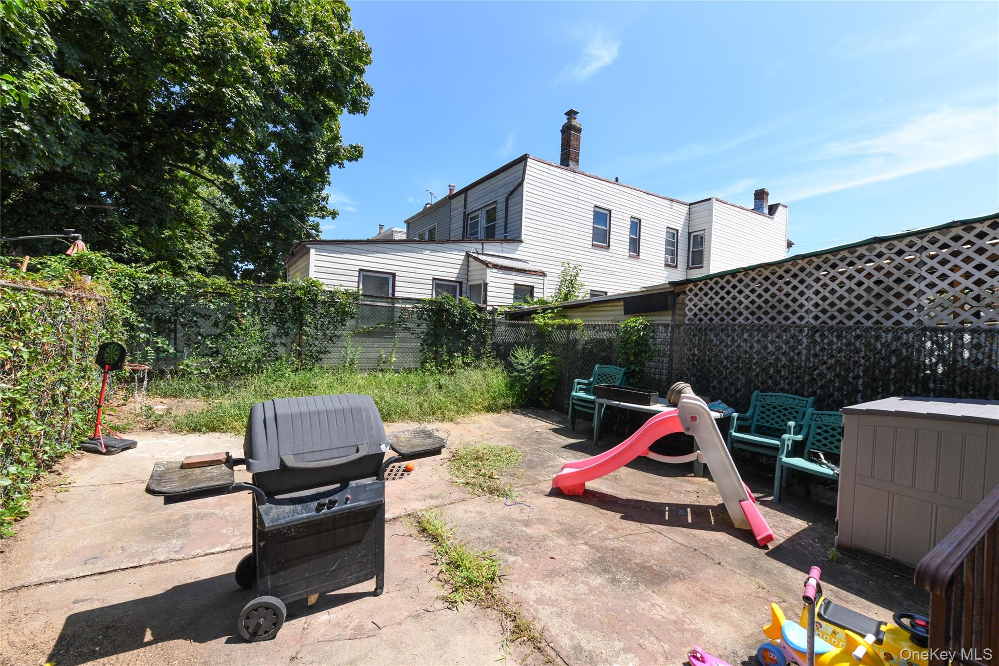 107-41 Sutphin Boulevard Queens, NY 11435 - Photo 3 of 19 Fenced backyard with a grill and a patio area