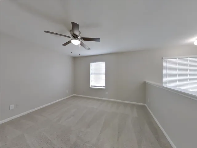 an empty room with a window and a fan