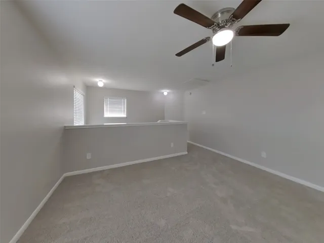 en empty room with ceiling fan and window