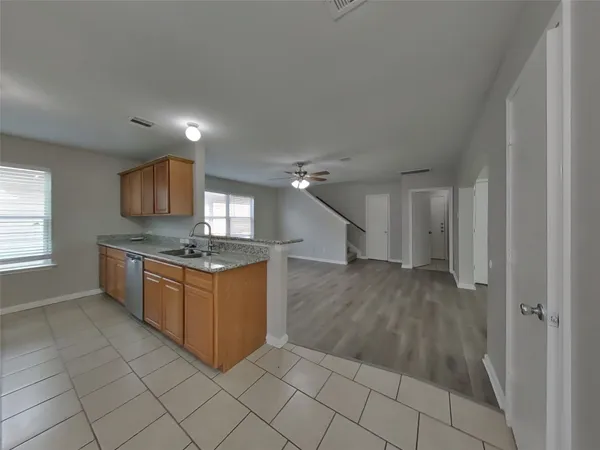 a large kitchen with a sink and dishwasher a stove with wooden floor