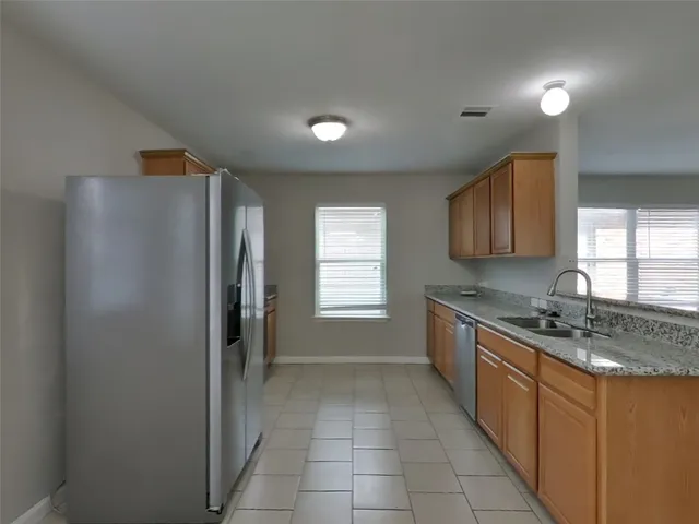 a kitchen with stainless steel appliances granite countertop a refrigerator and a stove