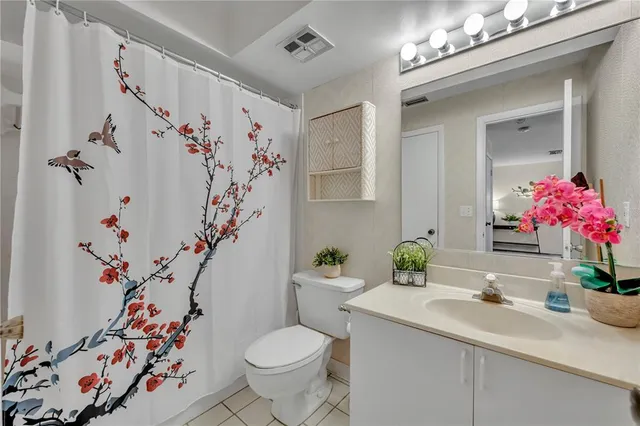 a bathroom with a sink a toilet and a shower curtain