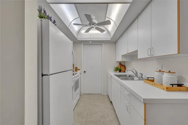 a kitchen with a refrigerator a sink dishwasher and a stove top oven