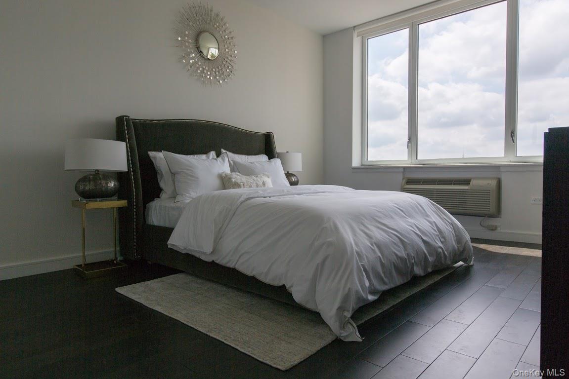 1 3rd, Unit 424 Mineola, NY 11501 - Photo 13 of 25 a bed sitting in a bedroom next to a window