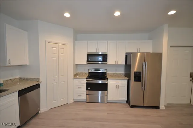 a kitchen with a refrigerator and a stove top oven