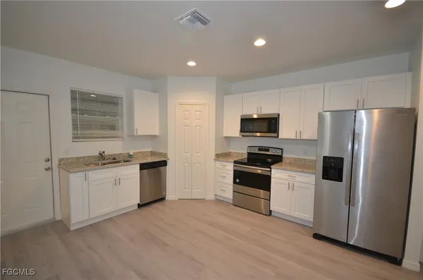 a kitchen with a refrigerator stove and sink