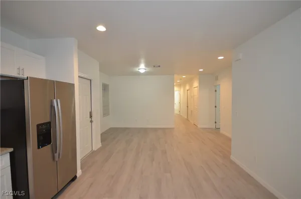 a view of a kitchen with a refrigerator wooden cabinets and a sink