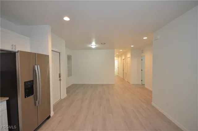 a view of a kitchen with a refrigerator wooden cabinets and a sink