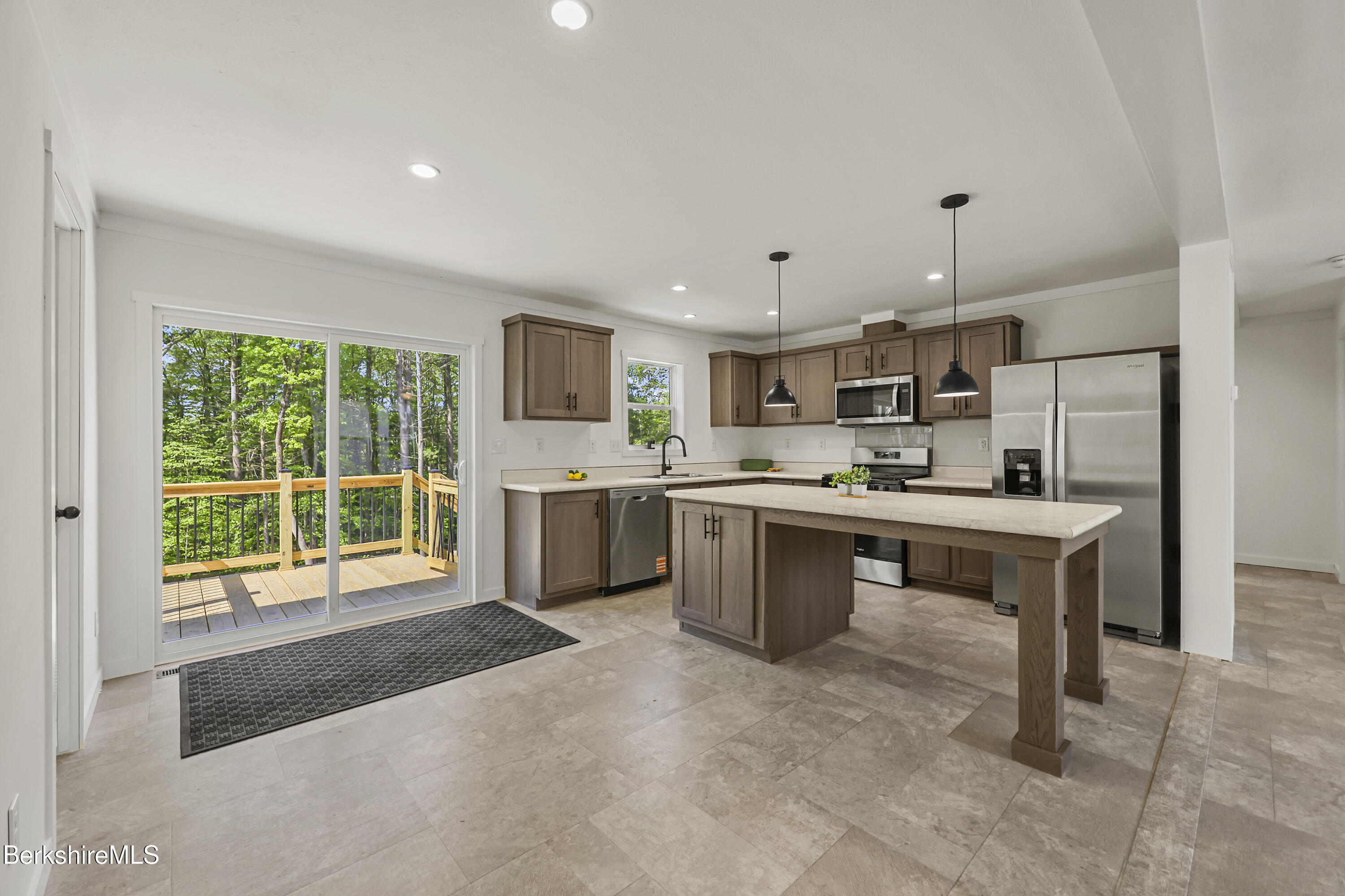 395 Cheshire Road, Unit 112 Pittsfield, MA 01201 - Photo 17 of 32 a open kitchen with kitchen island a sink stainless steel appliances and white cabinets