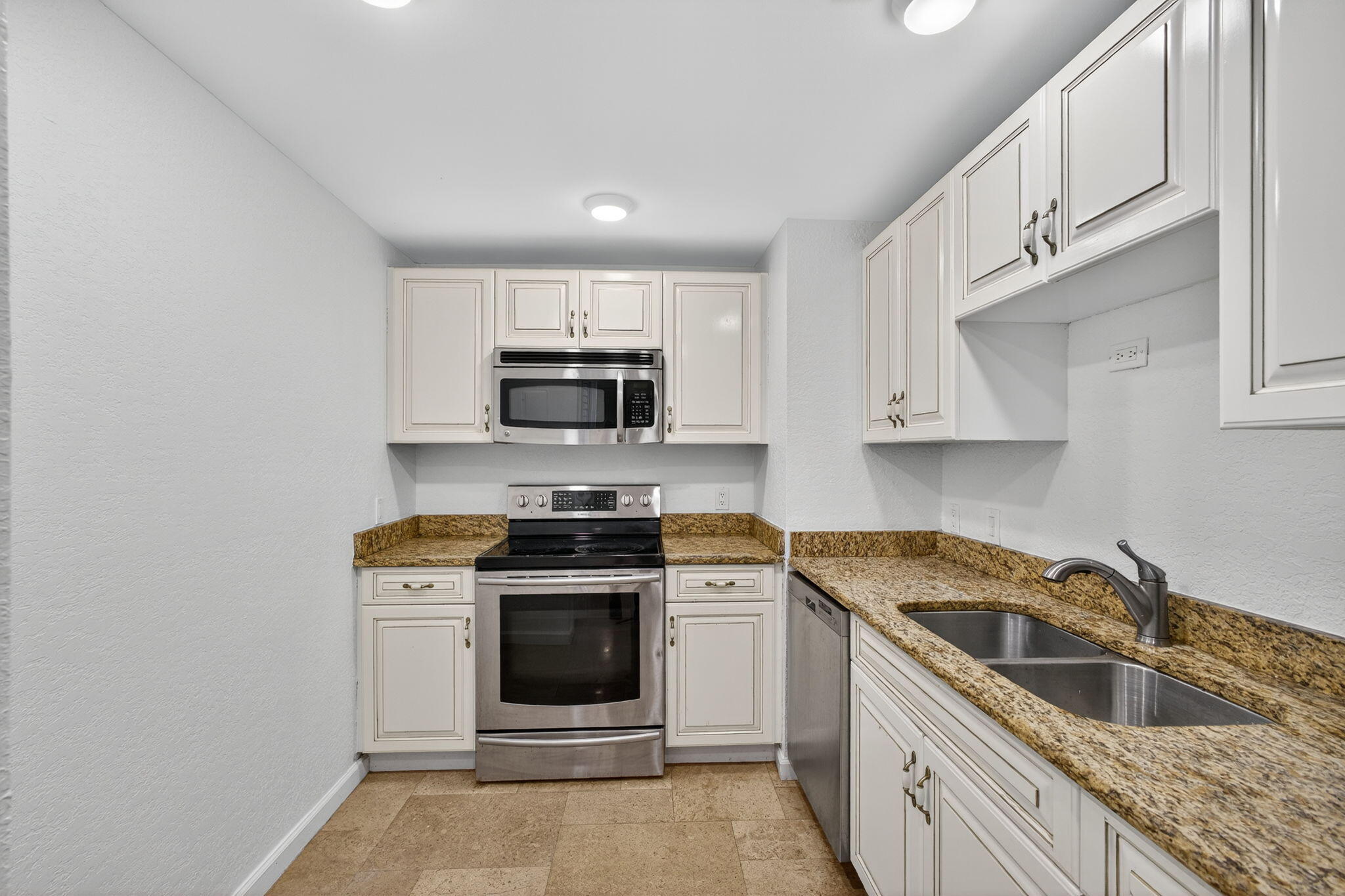 5600 North Flagler Drive, Unit 2703 West Palm Beach, FL 33407 - Photo 8 of 60 a kitchen with stainless steel appliances granite countertop a sink a stove top oven a counter space and cabinets