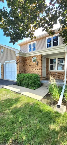 a front view of a house with a yard and potted plants