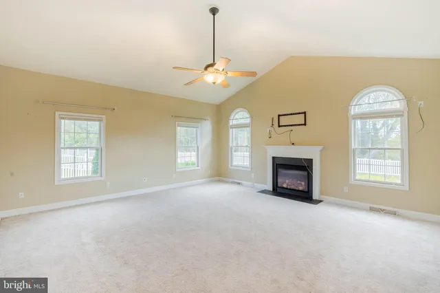 a view of an empty room with a fireplace and a window