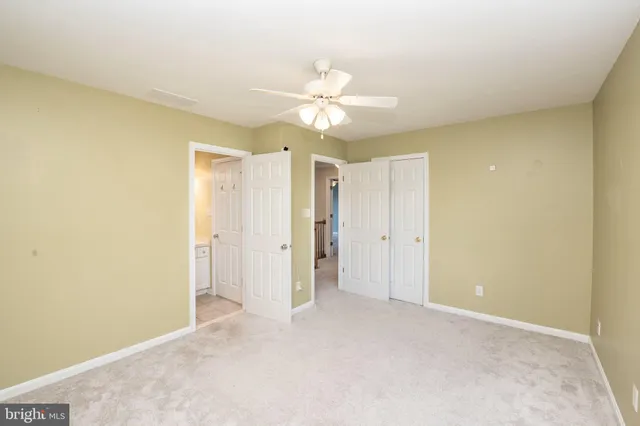 a view of an empty room and a ceiling fan