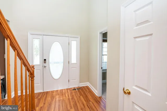 a view of a hallway with wooden floor and entryway