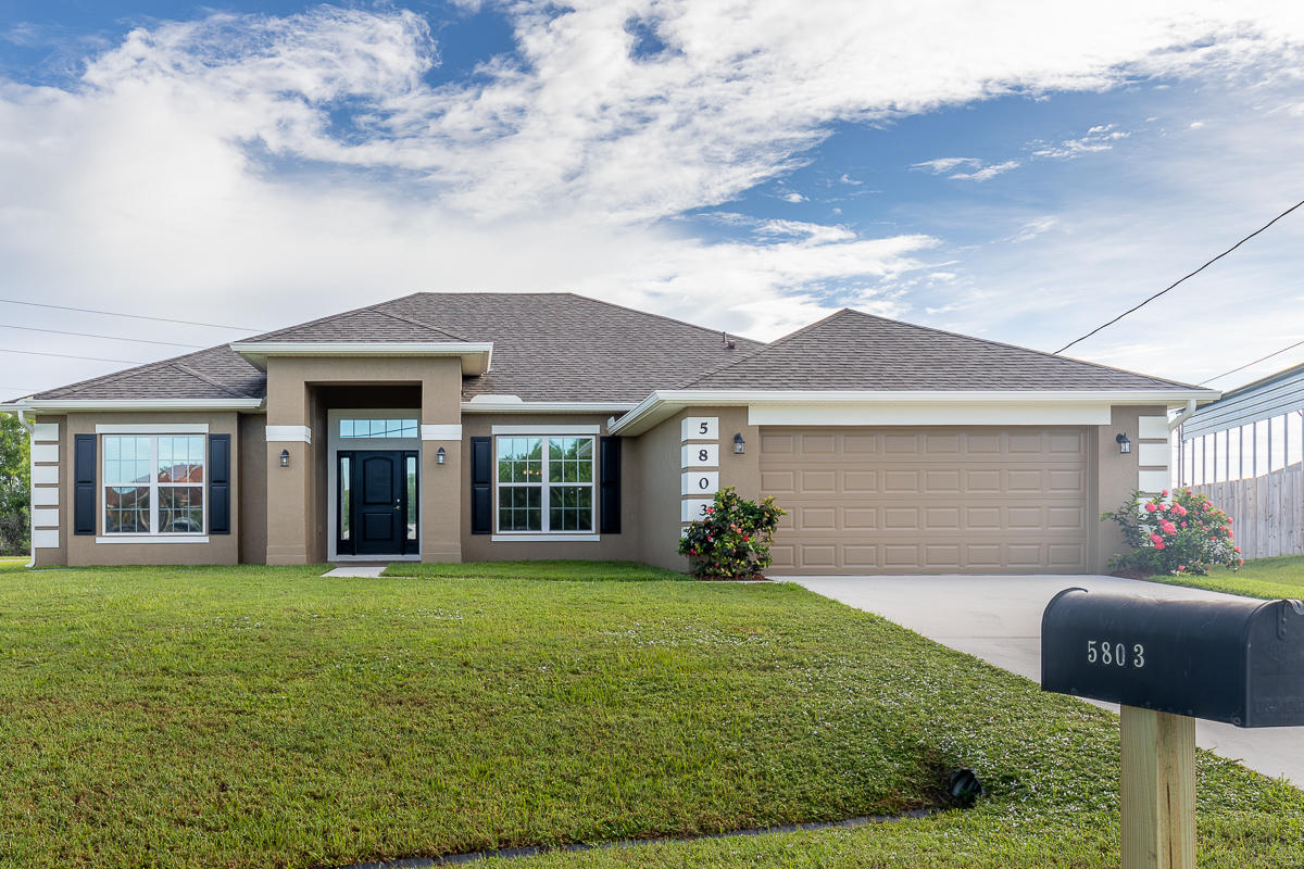 5803 Northwest S Dooley Circle Port St. Lucie, FL 34986 - Photo 1 of 26 a front view of a house with garden