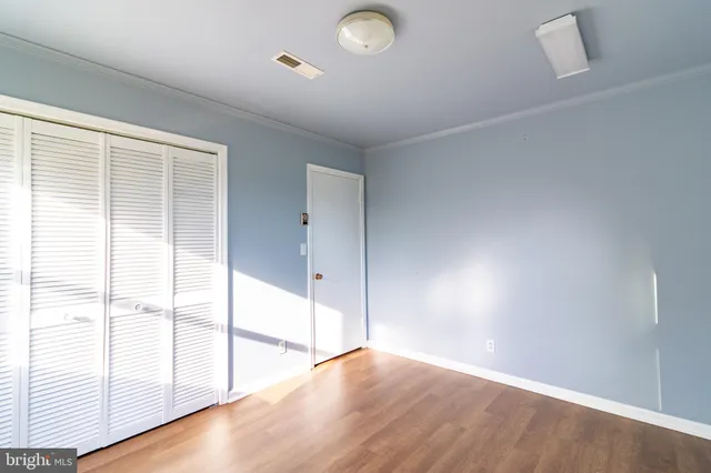 a view of an empty room with a chandelier fan