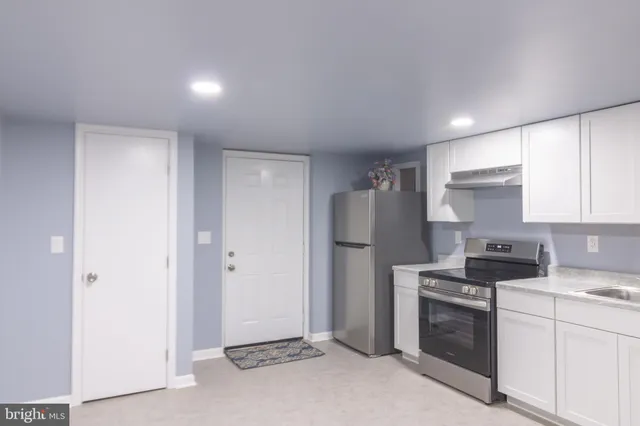 a kitchen with a refrigerator a stove and cabinets