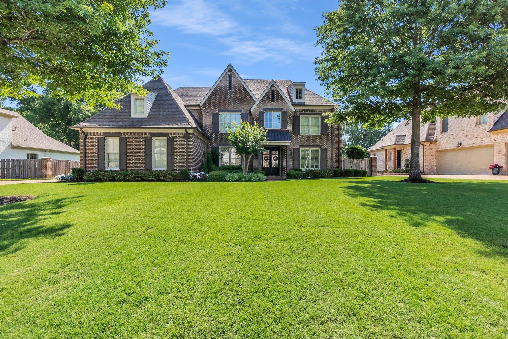 3246 North Hartwell Ridge Drive Collierville, TN 38017 - Photo 1 of 40 Brick-clad residence featuring a spacious front lawn, mature trees, dormer windows, shuttered windows, and a double entry door