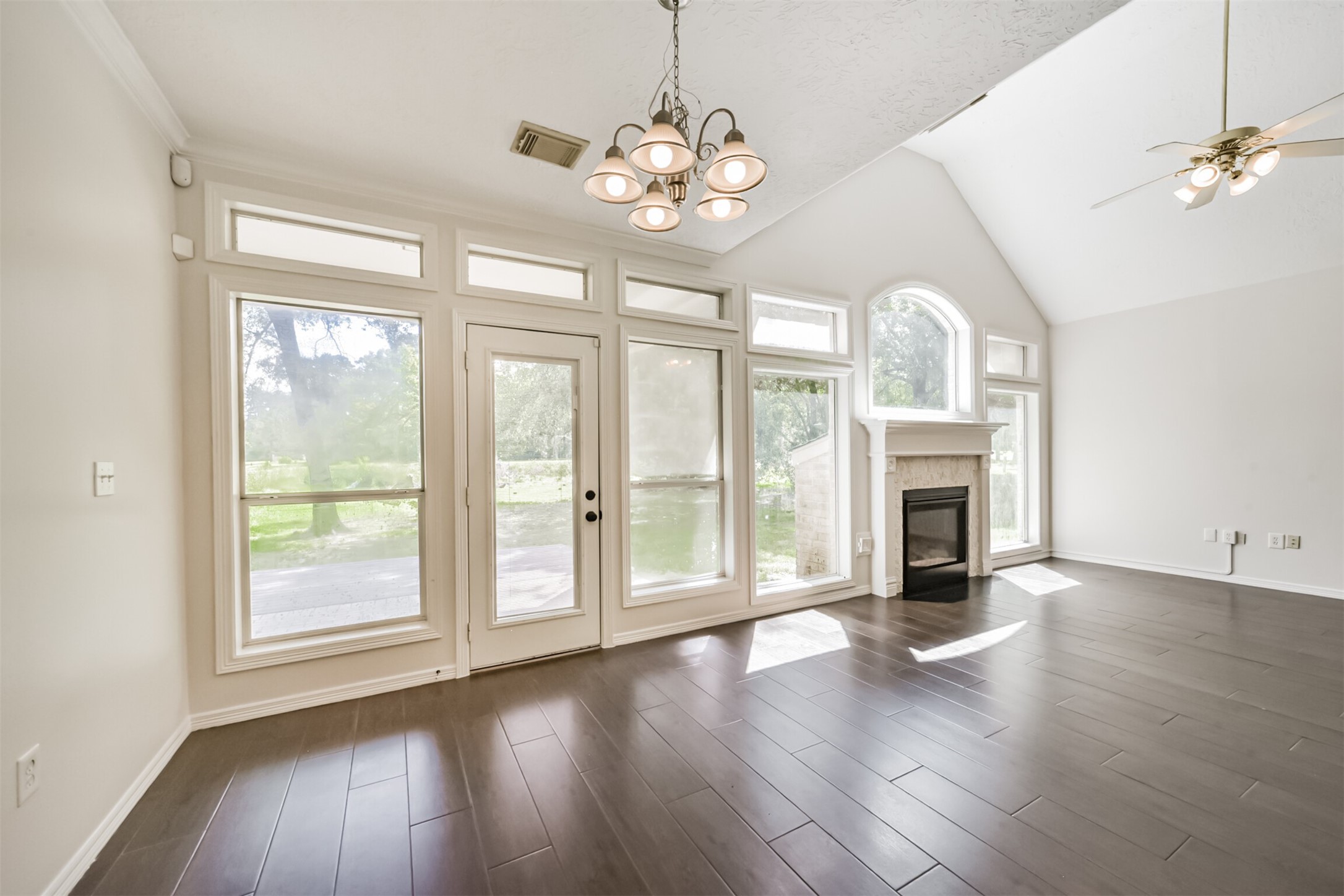 27322 Afton Way Huffman, TX 77336 - Photo 22 of 50 Wall of windows floods the living and dining spaces with natural light while showcasing serene backyard views and soaring ceilings.