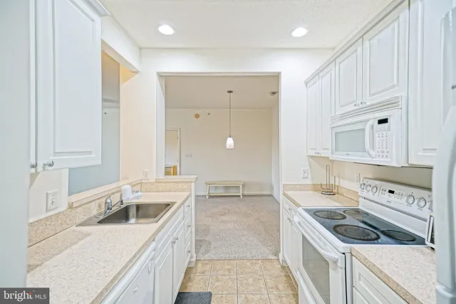 a kitchen that has a sink a stove and cabinets