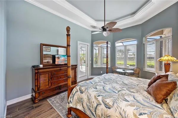 a bedroom with a bed dresser and a large window