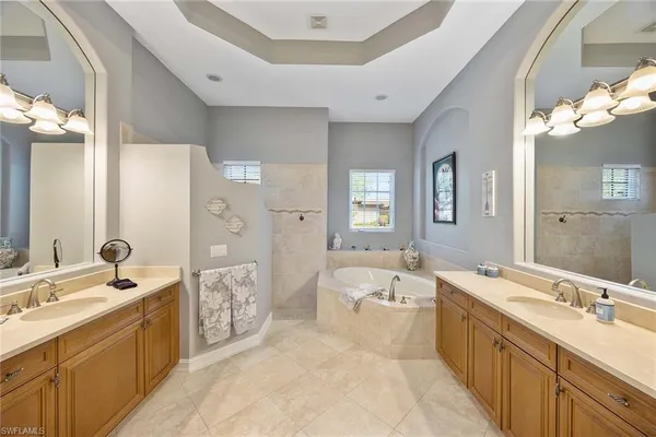 a large bathroom with a double vanity sink large mirror and a bathtub