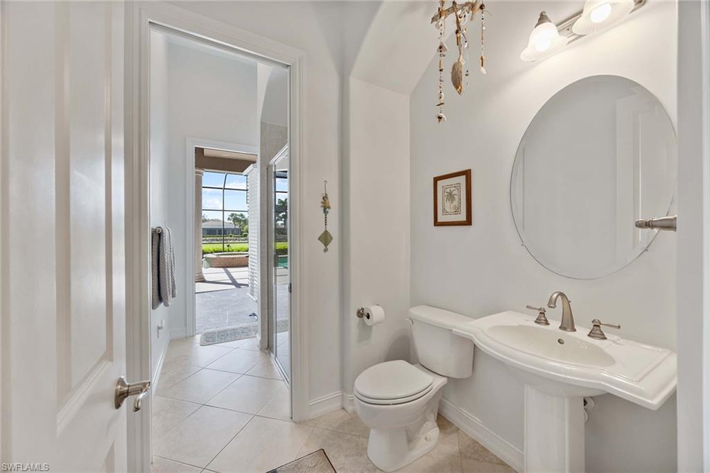 8902 Shenendoah Circle Naples, FL 34113 - Photo 16 of 28 a bathroom with a toilet sink and mirror